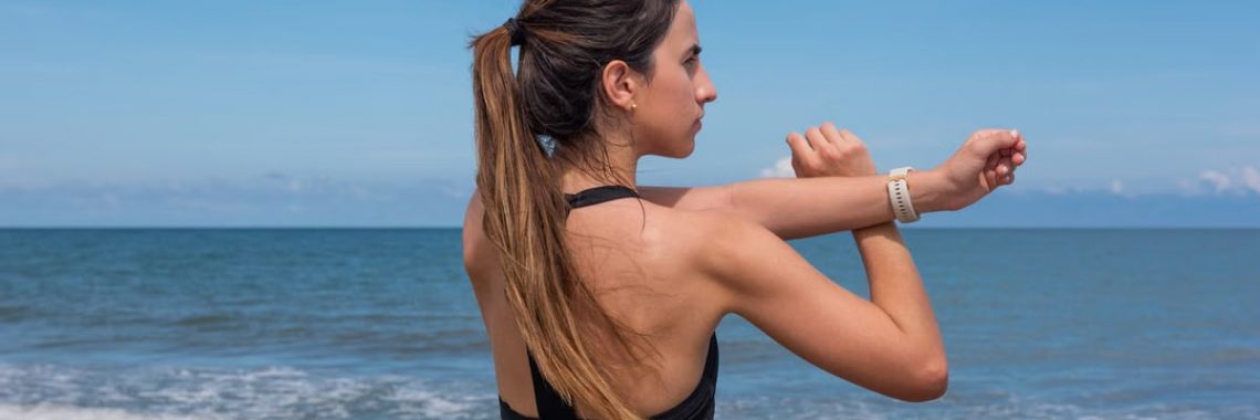 Fit woman stretching on Manzanillo del Mar beach in Colombia with ocean in background